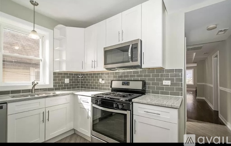 A kitchen with white cabinets and a black stove top oven.
