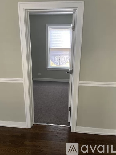 A white door with a window and a grey carpet.