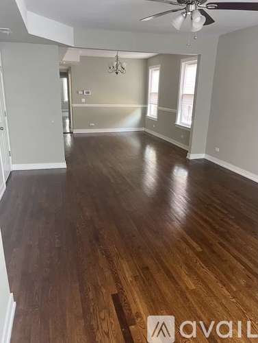 A room with wooden flooring and a ceiling fan.