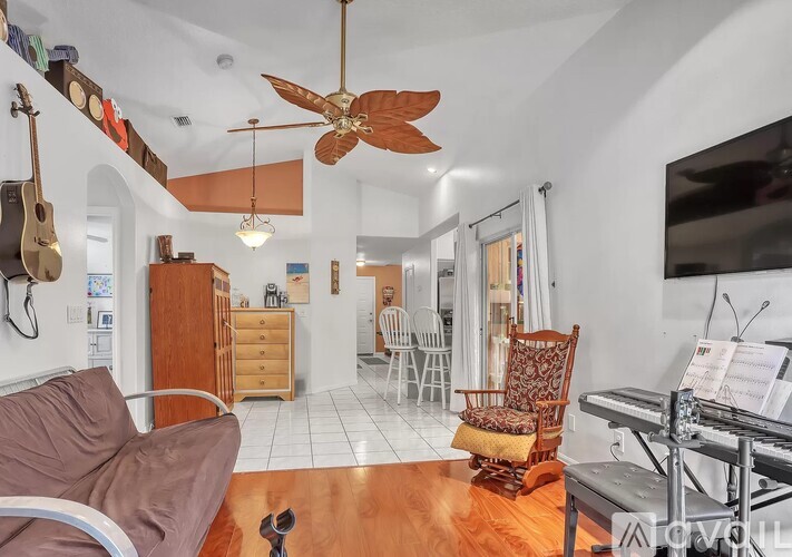A living room with a brown couch and a ceiling fan.