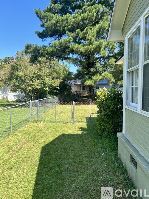 A backyard with a fence and trees.