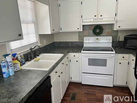 A kitchen with white cabinets and a white oven.
