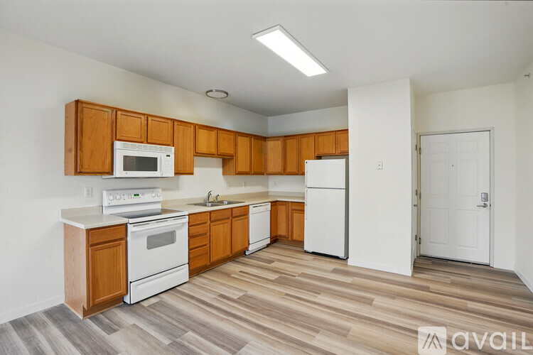 A kitchen with white appliances and wooden cabinets.