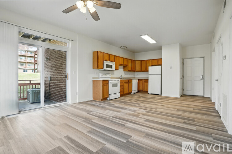 A spacious living room with wooden flooring and a ceiling fan.