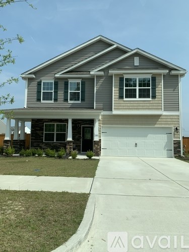 A two-story house with a garage and a driveway.