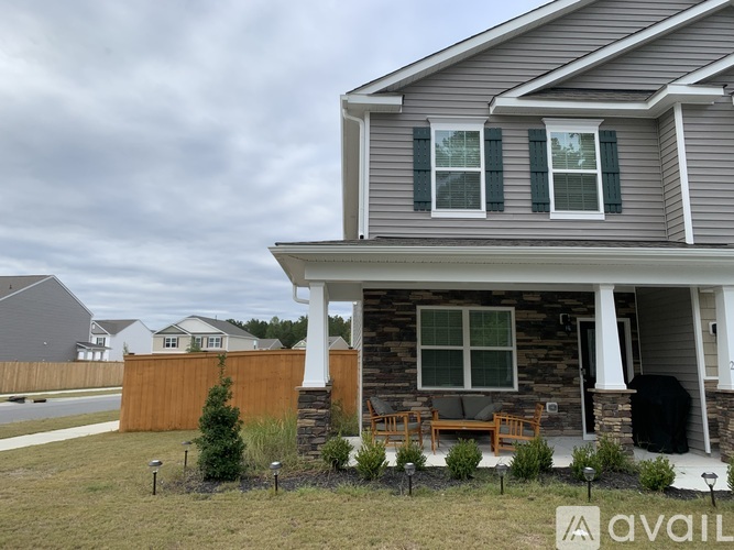 A house with a porch and a brown fence.