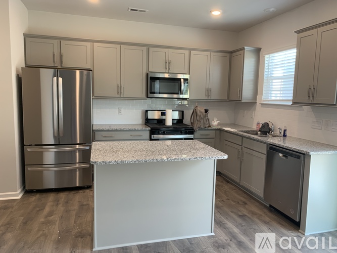 A kitchen with a refrigerator, microwave, and oven.