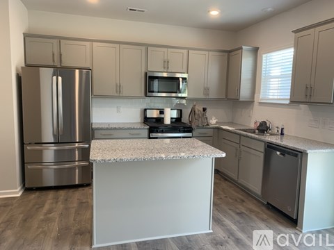 A kitchen with a refrigerator, microwave, and oven.