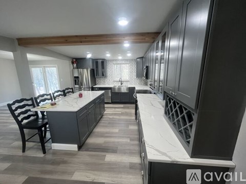 A modern kitchen with dark wood cabinets and a marble countertop.