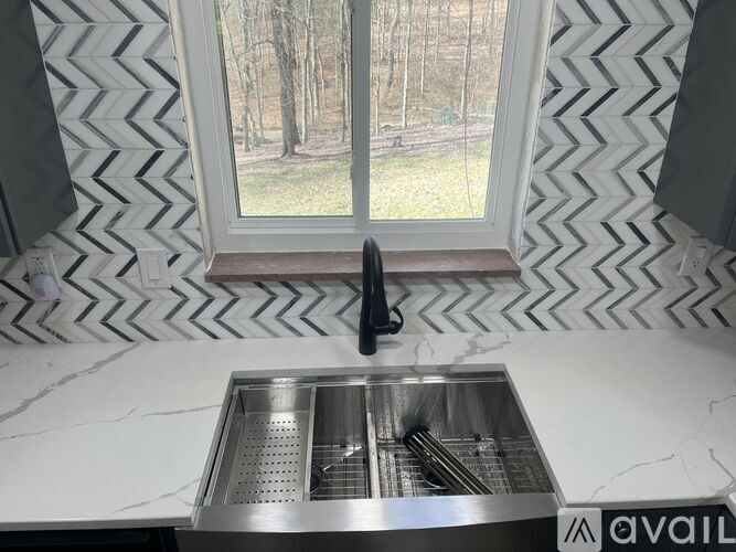 A kitchen sink with a window in the background.