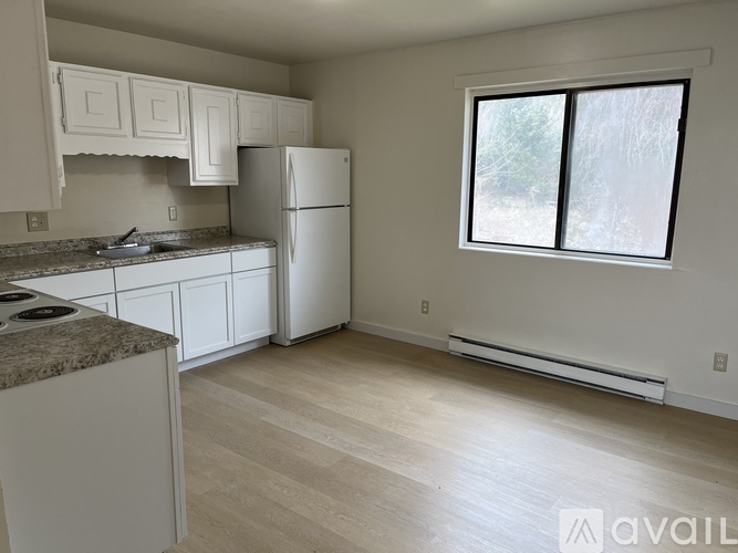 A kitchen with white appliances and cabinets is available for rent.