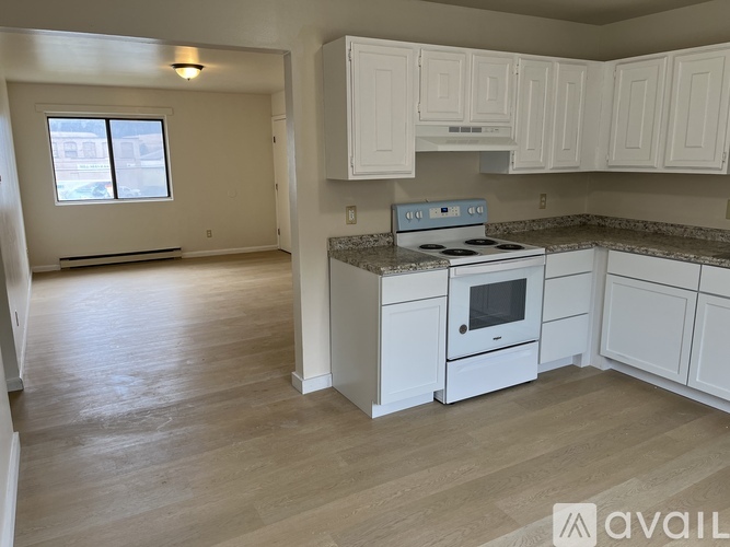 A kitchen with white cabinets and a stove top oven.