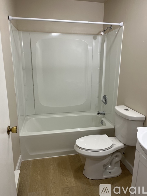 A white toilet sits next to a bathtub in a bathroom.