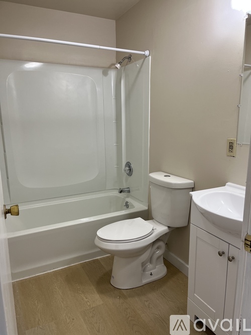 A white bathroom with a toilet, sink, and bathtub.