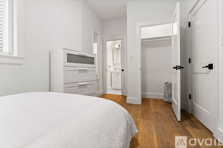 A bedroom with a bed, a microwave, and a small kitchenette.