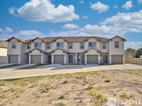 A row of houses with garages and driveways in front.