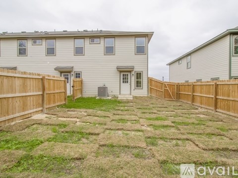 A backyard with a wooden fence and a grassy area.