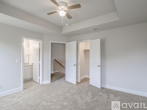 A spacious room with a ceiling fan and carpeted floor.
