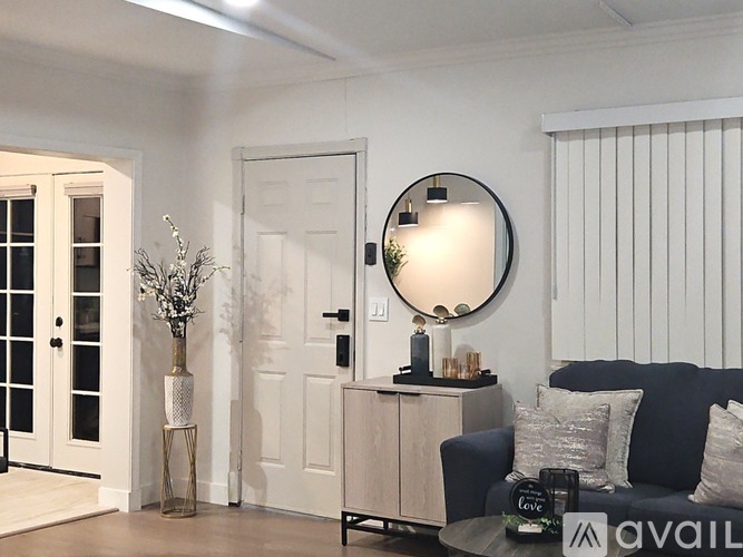 A living room with a round mirror, a sofa, and a coffee table.