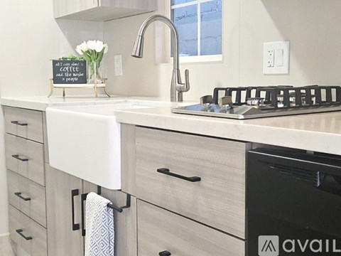 A kitchen with a white sink and black oven.