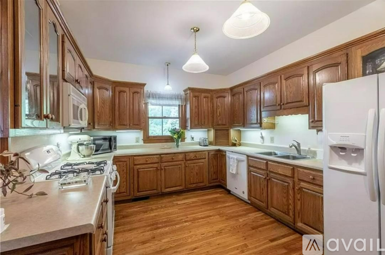 A kitchen with wooden cabinets and a white refrigerator.