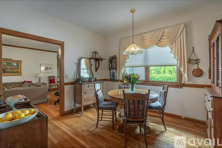 A dining room with a wooden table and chairs.