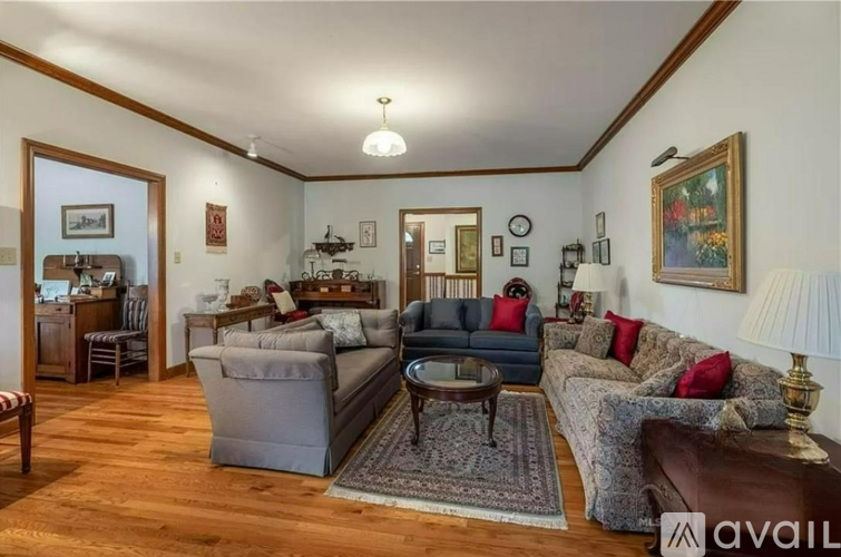 A living room with a grey couch and a brown leather couch.