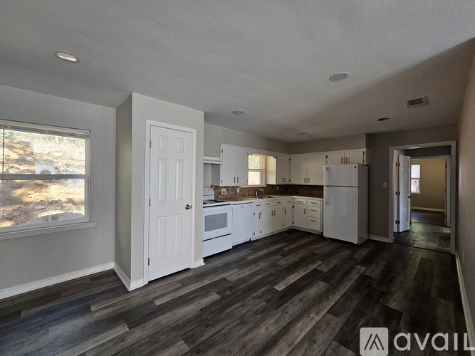 A kitchen with white appliances and cabinets is available for rent.