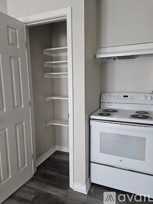 A white oven is in a kitchen with an open door.