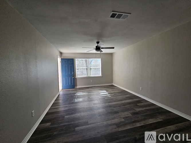 A room with a blue door and a ceiling fan.