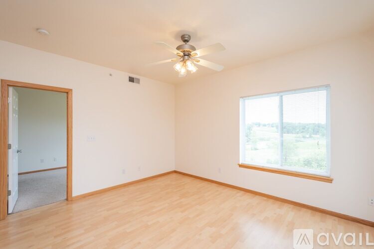 A room with a ceiling fan and a window.
