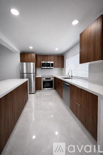 A modern kitchen with wooden cabinets and stainless steel appliances.