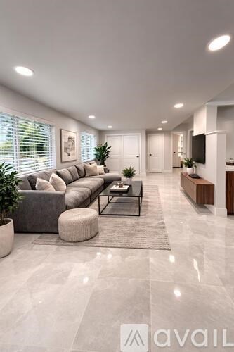 A modern living room with a grey sofa and a glass coffee table.