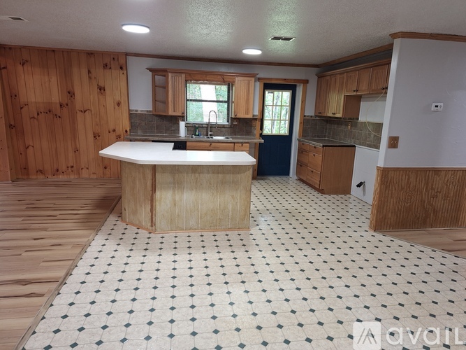 A kitchen with wooden cabinets and a checkered floor.