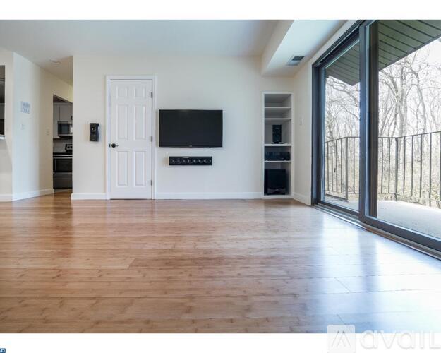 A spacious living room with a flat screen TV mounted on the wall.