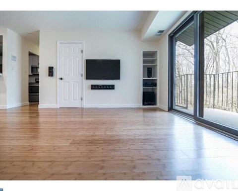 A spacious living room with a flat screen TV mounted on the wall.