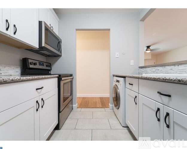 A kitchen with white cabinets and a washing machine.
