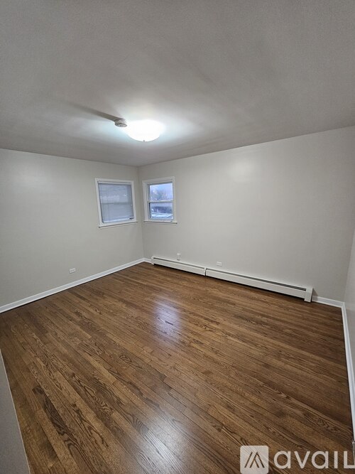 A room with wooden flooring and a window.