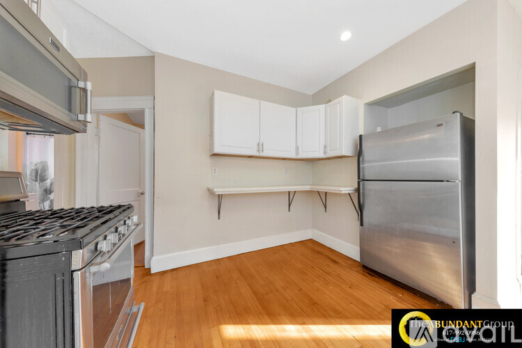 A kitchen with a stove top oven and a refrigerator.