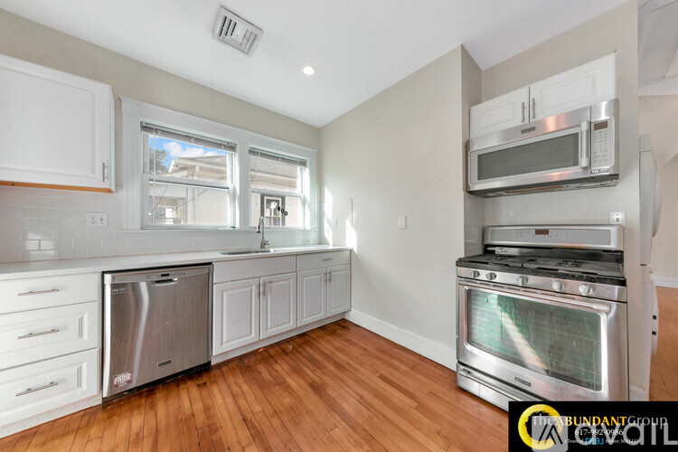 A kitchen with white cabinets and stainless steel appliances.