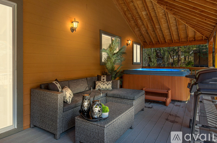 A patio with a hot tub and a couch.