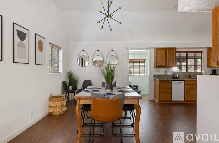 A dining room with a table and chairs and a basket on the floor.