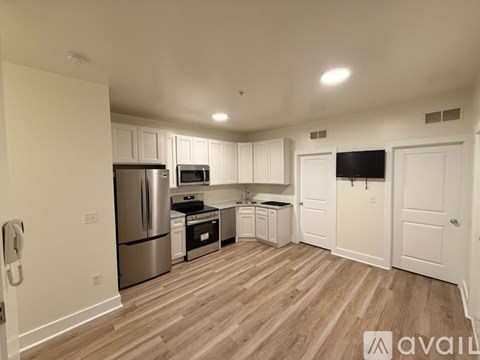 A kitchen with white cabinets and a wooden floor.