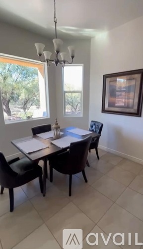 A dining room with a table and chairs.