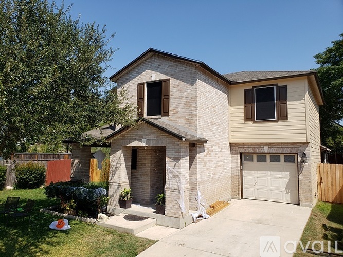A two-story house with a garage and a driveway.