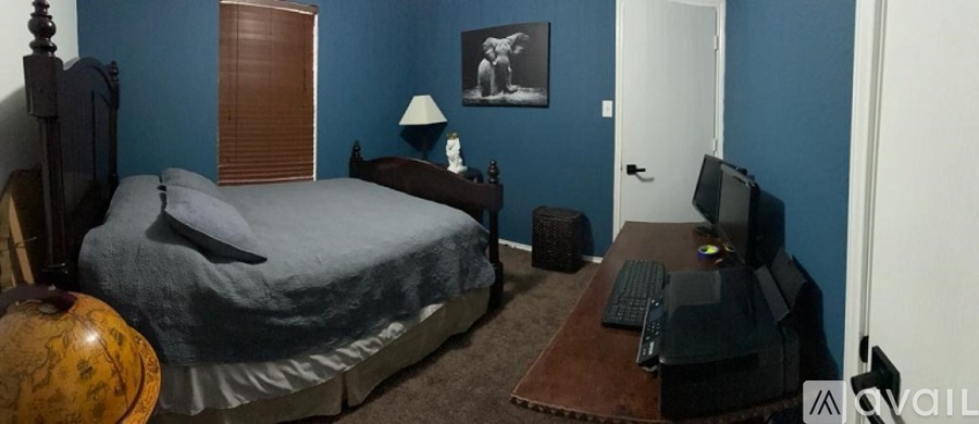 A bedroom with a bed, desk, and chair.