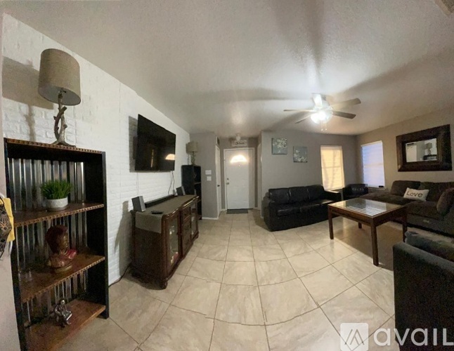 A living room with a black couch and a wooden coffee table.