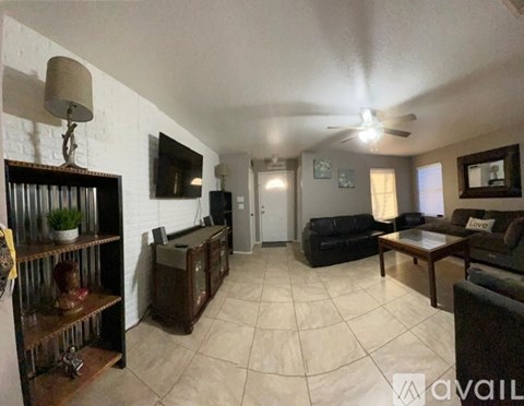 A living room with a black couch and a wooden coffee table.