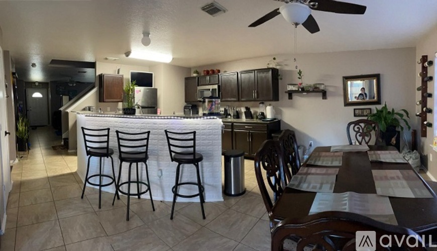 A kitchen with a dining table and chairs.