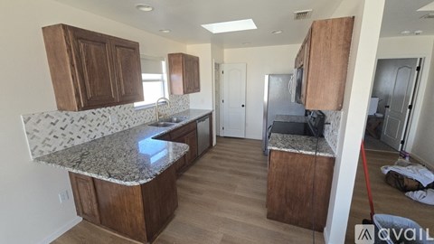A kitchen with granite countertops and wooden cabinets.